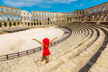 Tourist girl visiting the Coliseum of Pula, located in Istria, Croatia, can view a well-maintained Roman amphitheater. This structure was created by the Roman Empire between 27 BC and 68 AD.