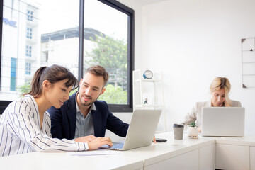 Young caucasian businessman is entrepreneur training businesswoman working confident together at office, manager and employee discussing and using laptop computer, two people, business concept.