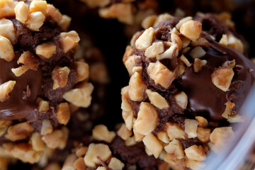 Close up of chocolate pods with crunchy nuts and chocolate sauce