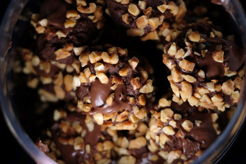 Close up of chocolate pods with crunchy nuts and chocolate sauce