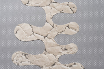 cut scrapbook paper with polyp or columnar edges on dotted gray paper
