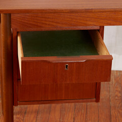 1960s Vintage Danish Teak Desk, minimalist design furniture. Close-up of drawers with houseplants in front of a white curtain.