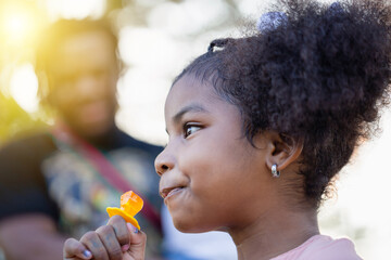 Kid with ring pop candy in park, Girl enjoy with ring candy pops