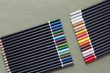 two sets of generic pencil crayons or colored pencils arranged according to their cool or warm hues or shades