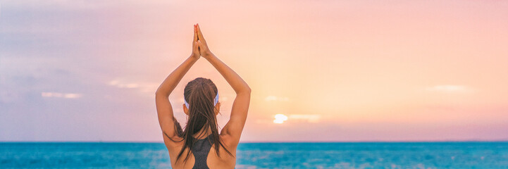 Yoga meditation woman meditating at beach sunset relaxing in yoga tree pose doing sun salutation. Relaxing serene woman enjoying sunshine banner panorama