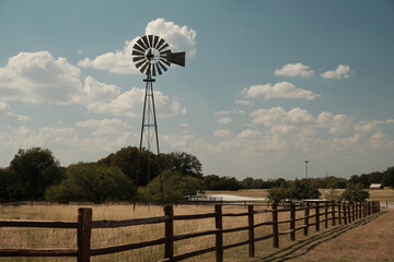 classic American windmill in a rural farming landscape in warm vintage colors