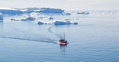 Icebergs and tourist boat in Greenland iceberg landscape of Ilulissat icefjord