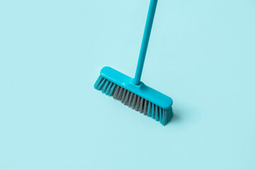 Blue plastic broom on color background