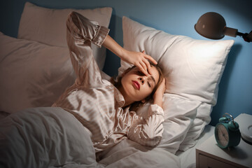 Young woman lying in bed at night