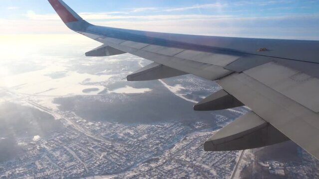 View from an plane window. Airplane flying over a snow-covered city. The concept of traveling by aircraft.