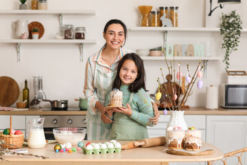 Little girl and her mother with Easter cake cooking in kitchen