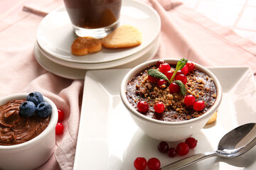 Bowls of delicious chocolate pudding with berries on pink napkin