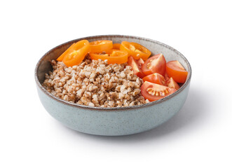 Bowl of tasty buckwheat porridge with fresh vegetables isolated on white background