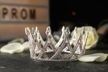 Beautiful tiara and rose petals on dark table, closeup. Prom concept © Pixel-Shot