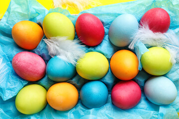 Fototapeta na wymiar Holder with colorful Easter eggs and feathers, closeup