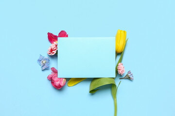 Composition with spring flowers and blank card on color background