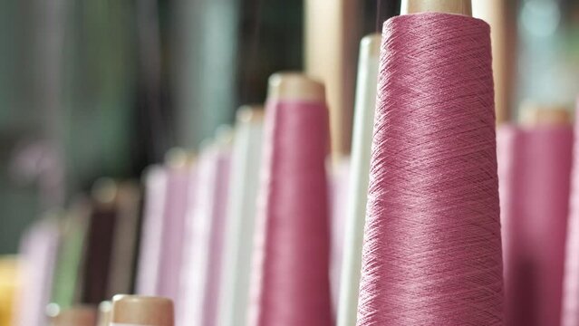 Pink cotton spooling off  of spool.