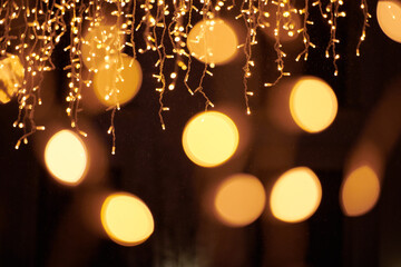 Yellow lights bokeh from christmas holiday garlands, blurred festive background, abstract outdoor...