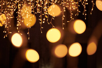 Yellow lights bokeh from christmas holiday garlands, blurred festive background, abstract outdoor lights with boke. Bright yellow bokeh lights with beautiful shiny on dark night background
