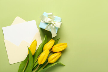 Envelope with blank card, tulips and gift on green background. Hello spring