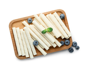 Board with delicious wafer rolls, blueberries and mint isolated on white background