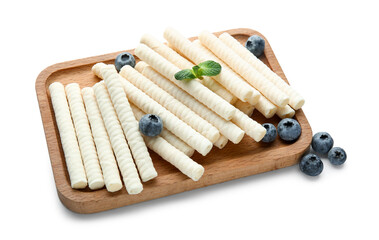 Board with delicious wafer rolls, blueberries and mint isolated on white background
