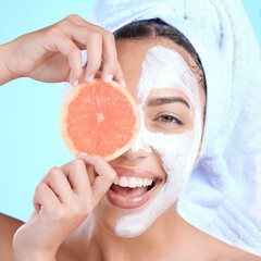 Portrait, skincare and woman with grapefruit mask in studio for beauty, hair and cosmetics on blue background, Face, facial and girl model relax with fruit, luxury and product, wellness or isolated