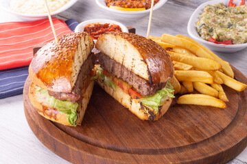 Big sandwich - hamburger with juicy beef burger  cheese  tomato  and red onion on wooden background