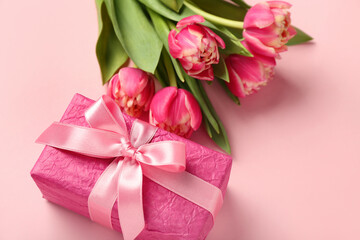 Gift box and beautiful tulip flowers on pink background. Hello spring