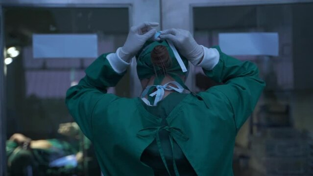 Portrait of a female surgeon getting ready wearing a mask in a hospital operating room.