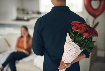 Man, hands and red roses behind back for valentines day surprise, gift or present to celebrate date at home. Hand of male with bouquet of flowers in celebration anniversary for special month of love