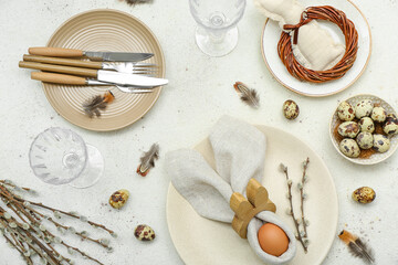 Table setting with Easter eggs, pussy willow branches and feathers on white background