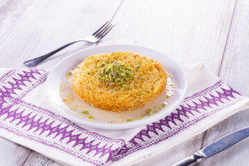 Kanafeh.Turkish dessert kunefe, kunafa, kadayif with pistachio powder and cheese, served hot, very sweet. Turkish traditional dessert Künefe tatlısı, antep fıstıklı