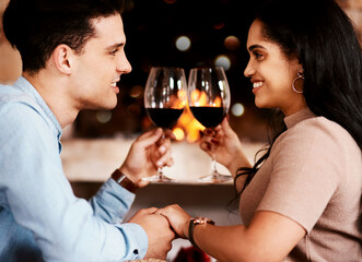 Date night, wine and fire with couple holding hands at restaurant with love and care. Anniversary celebration, valentines day and happiness of young people together with alcohol in glass with cheers
