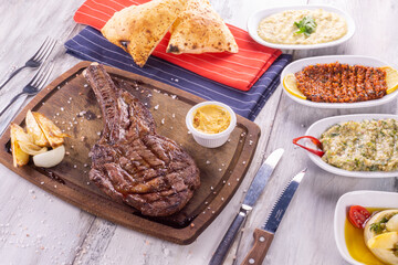Grilled beef steaks with spices. on wood background with sauce 