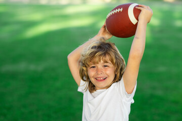 American style football. Kids and sports. Young boy playing american football. Child holding rugby ball while playing american football in Summer park.