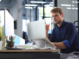 Elegant modern businessman analyzing data while working in office