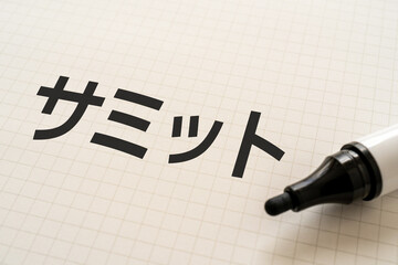 サミットと書かれたノートとマーカー