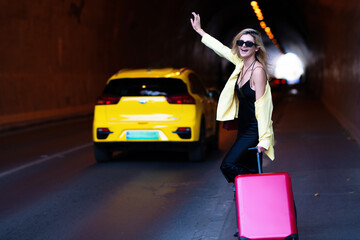 Woman with a suitcase take taxi. Yellow taxi. Travelling concept. Sexy young woman on trip walking...