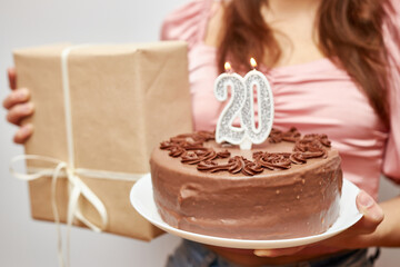A photo with a blurred focus for use as a background. The girl is holding a festive cake with a...
