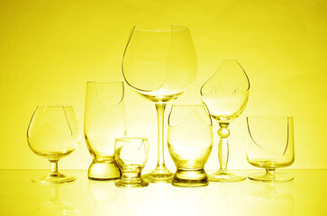 Transparent broken glasses on a yellow background.
