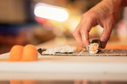Watch as a sushi chef rolls fresh salmon into perfect sushi rolls. Ideal for cooking and foodie content. Salmon sushi rolls on a bed of rice and seaweed. Ideal for menu and gourmet food photography
