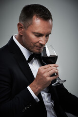 Tuxedo, wine glass and man with alcohol in a suit feeling classy with a luxury drink. Gray...