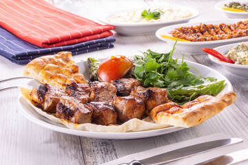 Asian style grilled beef skewers on a wood background, top view. Delicious appetizer, tapas, snack, turkish