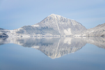 reflection of snowcovered mountain by the ocean