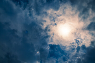 View of the calm cloudy sky through the clouds the rays break through on a summer day.