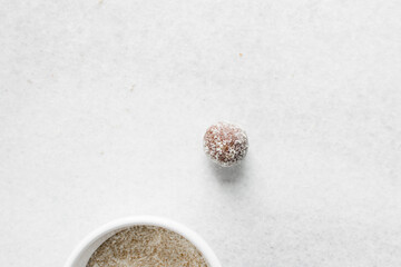 Top view of Coconut and chocolate truffles, homemade chocolate bonbons on white background, desiccated coconut coated truffles	