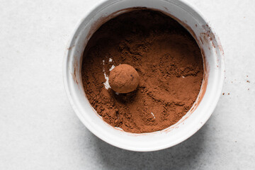 Top view of chocolate truffles covered in cocoa powder, homemade chocolate bonbons in a ramekin with cocoa powder