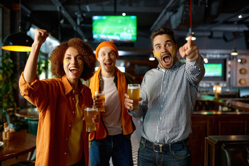 Group of emotional friends watching soccer in pub