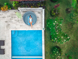 Aerial view of attractive woman near the pool at resort